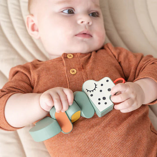 Bebé jugando con Juguete giratorio Croco Verde - Done by Deer